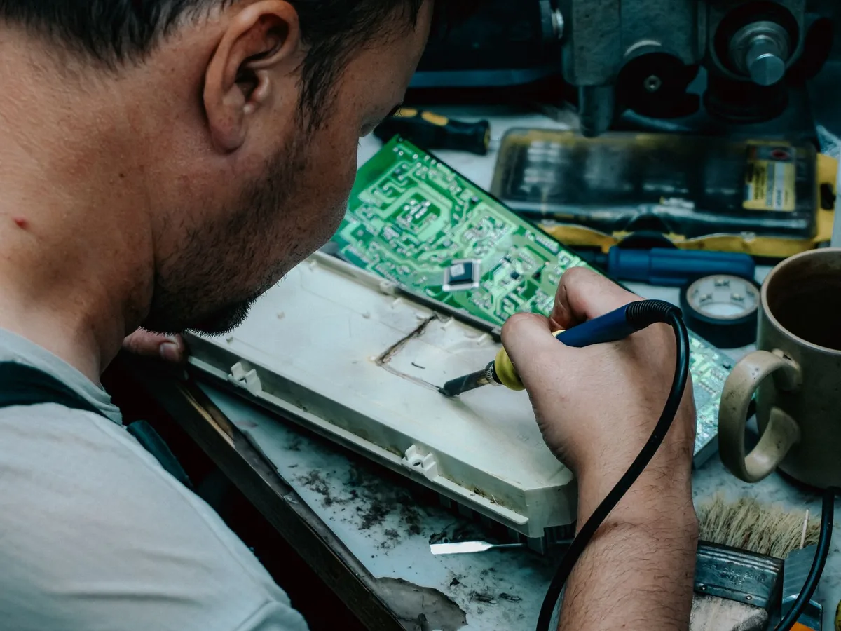 Bàn sửa chữa điện tử với dụng cụ và bảng mạch