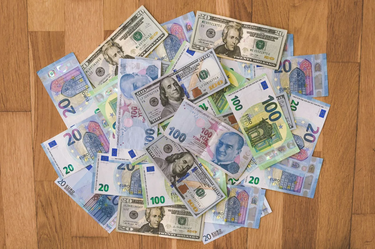 Tờ tiền đô la Mỹ và euro đặt trên mặt bàn